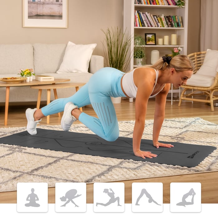 kobieta ćwicząca na macie do jogi marki Hop-Sport w salonie