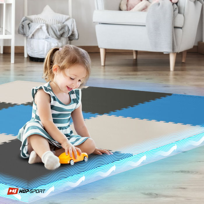 Dziecko siedzące na macie puzzle Hop-Sport czarno-biało-niebieskiej