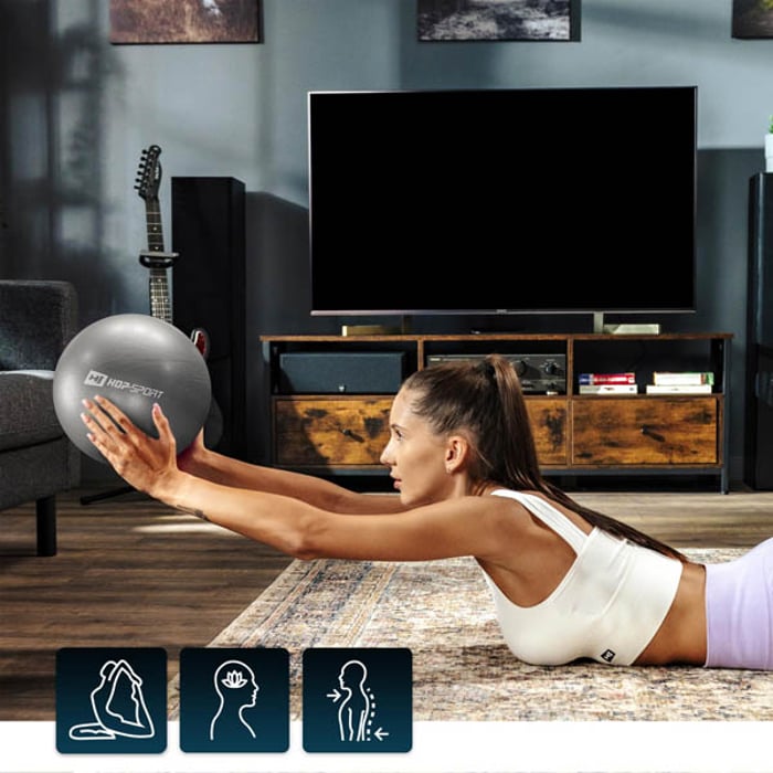 Piłka pilates 25cm srebrna marki Hop-Sport z modelką robiącą przysiady