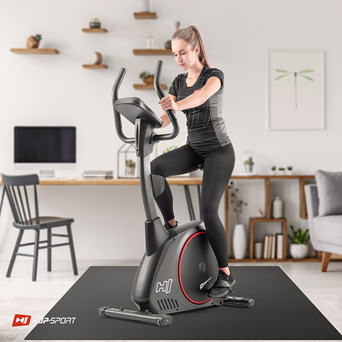 Dziewczyna ćwicząca na sprzęcie fitness, który stoi na czarnej macie puzzle 1 cm 12 sztuk 