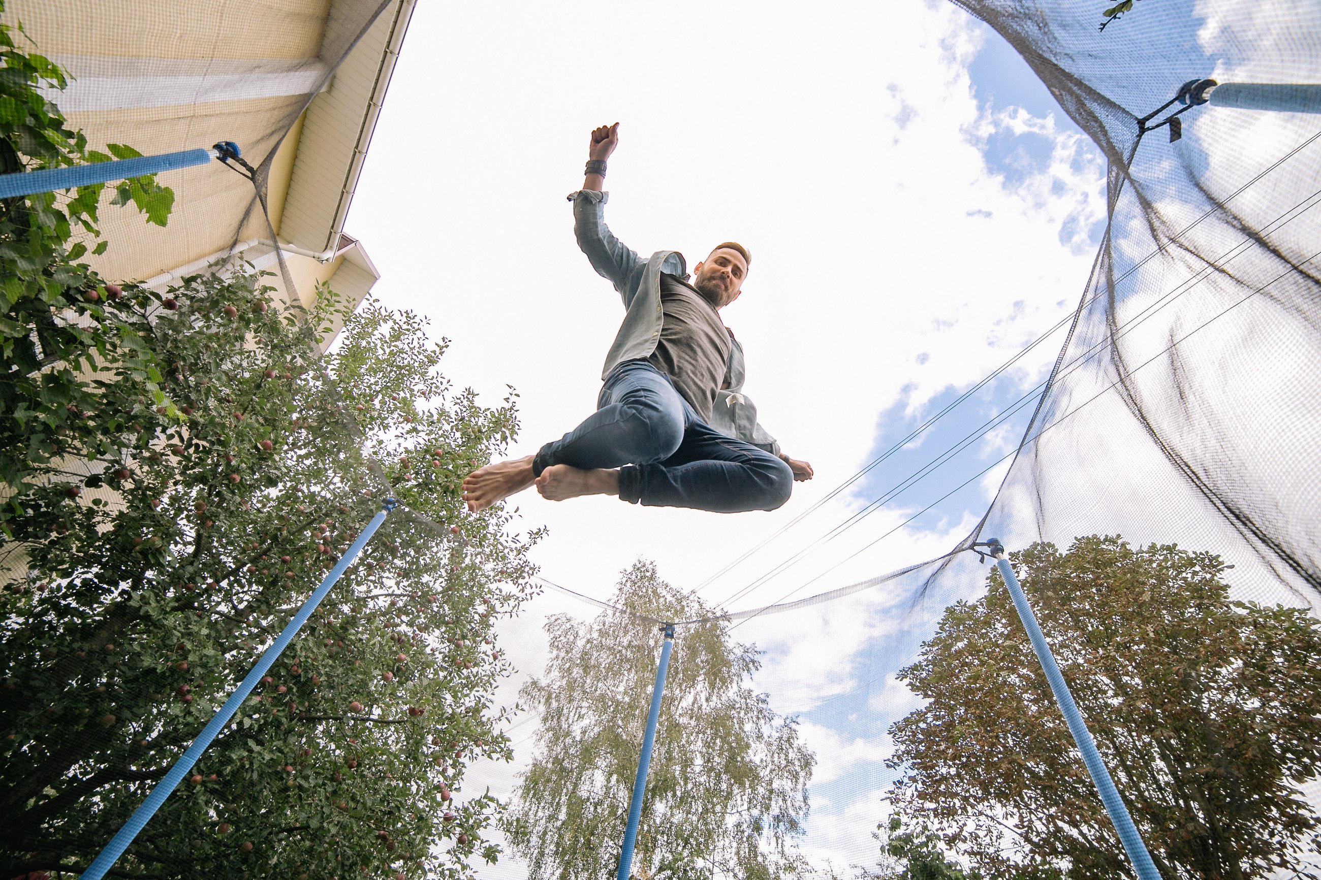 mężczyzna skaczący na trampolinie ogrodowej