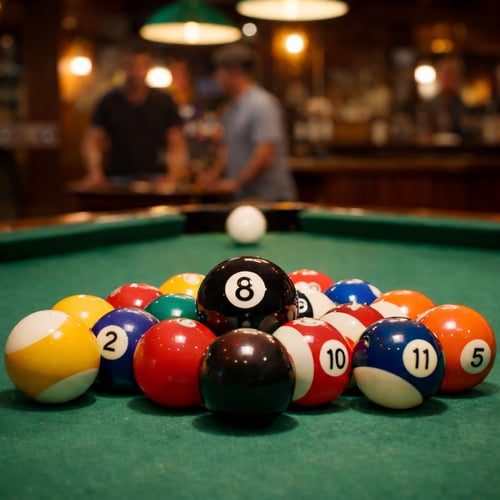 Close-up of racked American pool balls on a green table with the black 8-ball in focus, showing a popular variation of billiards in a bar setting.