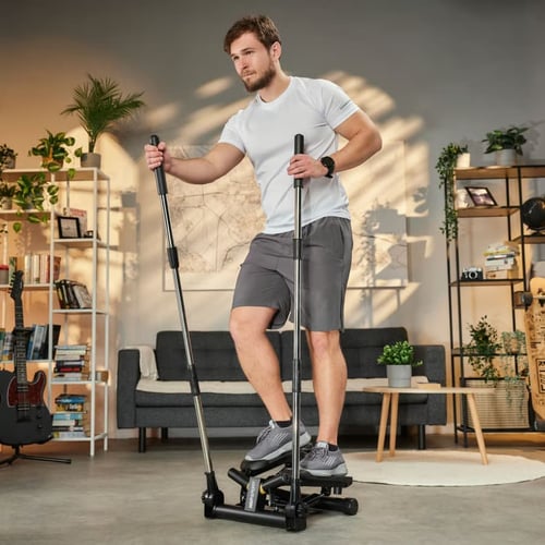 Mężczyzna trenujący w domu na stepperze z drążkami – przykład sprzętu użytecznego przy wyborze, jaki stepper kupić do efektywnego treningu cardio i nóg.