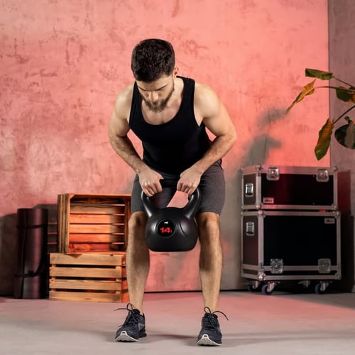Zbliżenie na zestaw czterech kettlebelli o wadze od 10 kg do 18 kg ustawionych na podłodze w stylizowanej przestrzeni treningowej – idealny wybór do ćwiczeń takich jak kettlebell halo.