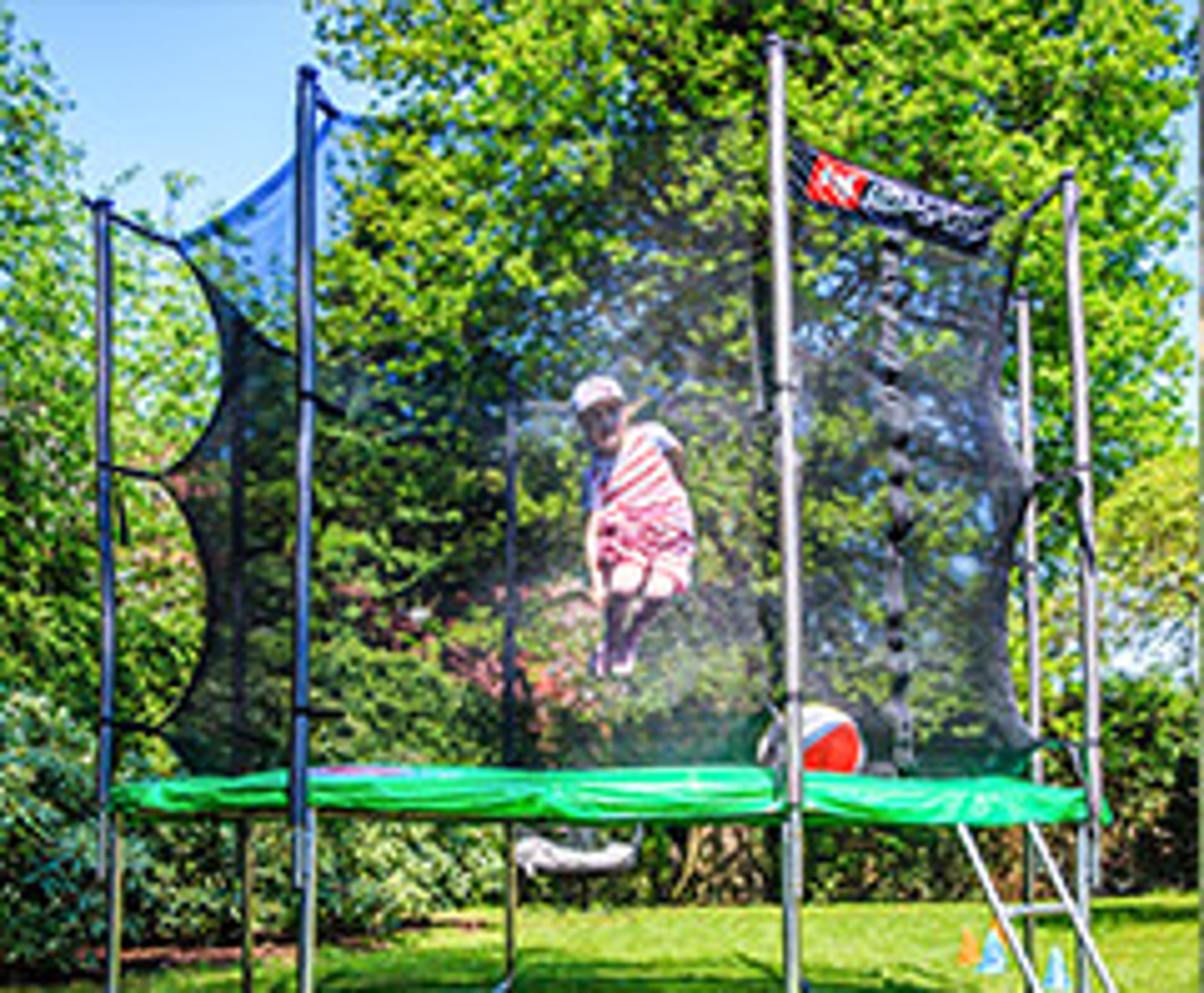 dziecko skaczące na trampolinie w ogródku