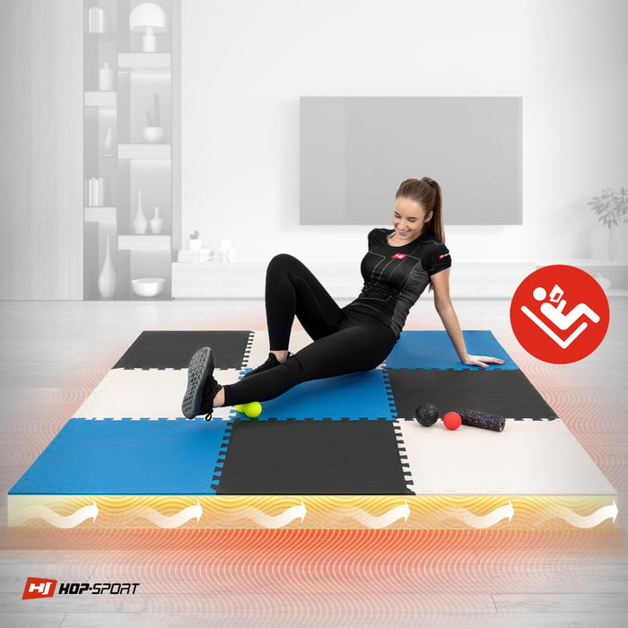 Dziewczyna siedzaca na macie Puzzle Hop-Sport czarno-biało-niebieskiej