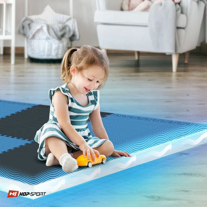 Dziecko siedzące na czarno-niebieskiej macie puzzle Hop-Sport