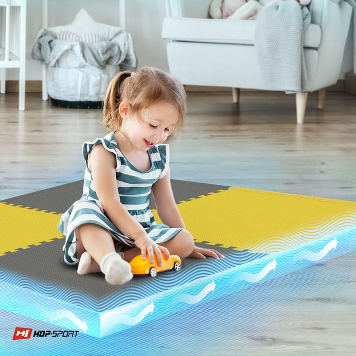 Dziecko siedzące na żółto-szarej macie puzzle Hop-Sport