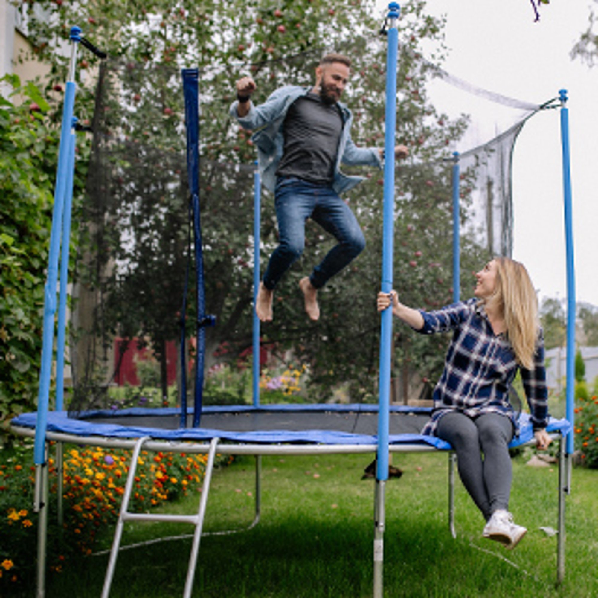 mężczyzna skaczący na trampolinie ogrodowej