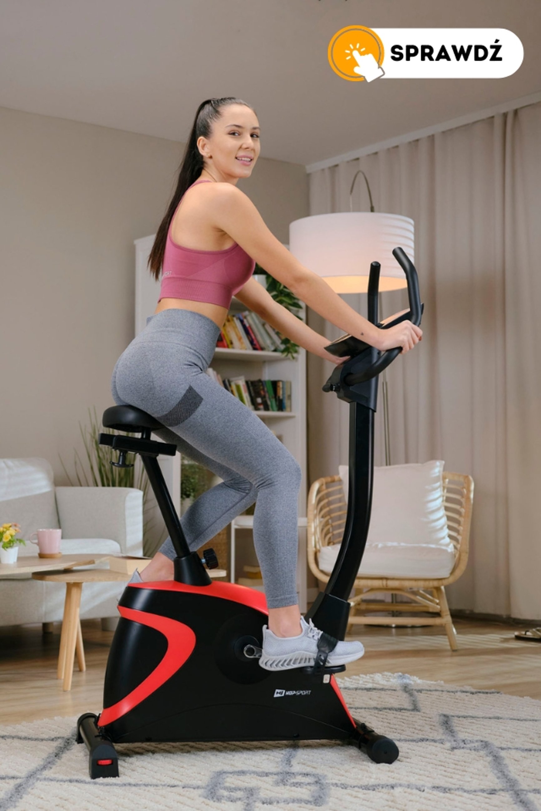 modelka ćwicząca na rowerze stacjonarnym HS-005H Host czerwonym marki Hop-Sport